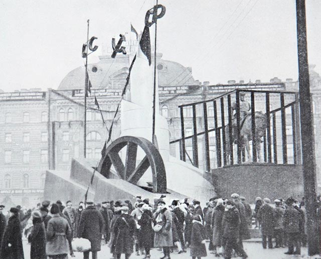 7 ноября 1927 года. Ленинградцы рассматривают заключенный в фанерную клетку памятник Александру III на площади Восстания. По сюжету книги, через несколько минут сюда прибудут Сталин и Ворошилов.